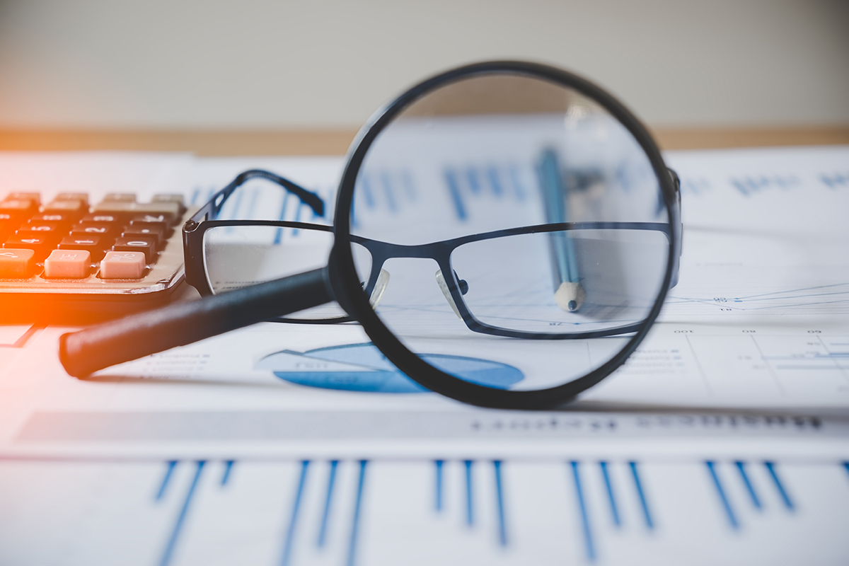 Magnifying glass and glasses on financial information