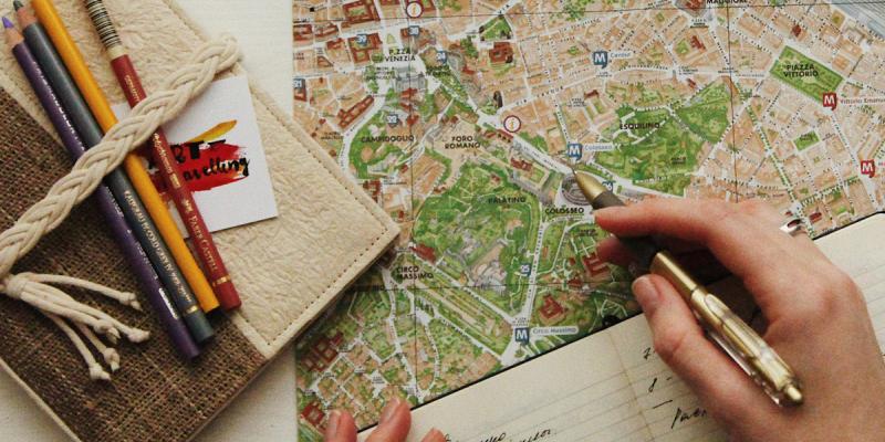 Map, book, pencils. Photo by oxana v on Unsplash